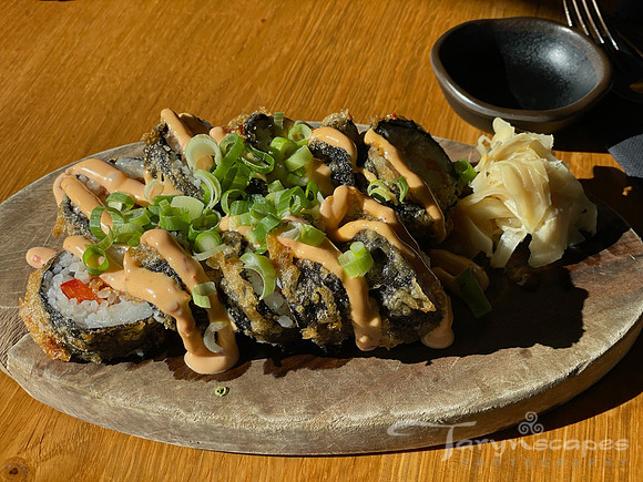 Fried sushi roll with scallions and spicy sauce