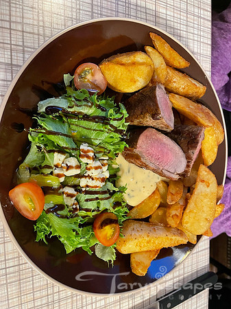 Another plate of salad with balsamic, tomatoes and blue cheese, lamb and potato wedges.