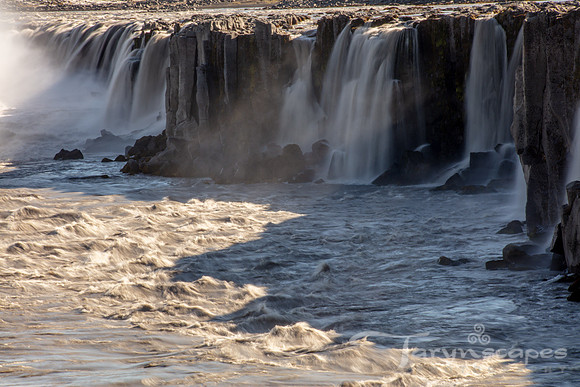 Close up of a waterfall spilling over the edge of a cliff that is hundreds of fee wide.