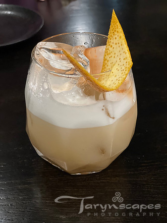 A peach cocktail with frothy top