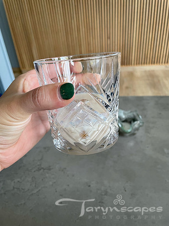 my hand holding a lowball glass with a creamy liquor