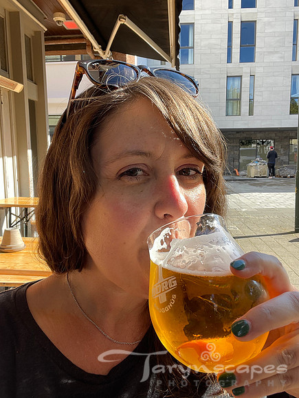 Me, with my hair down, sunglasses on my head. I'm drinking a pint of beer in the sunshine