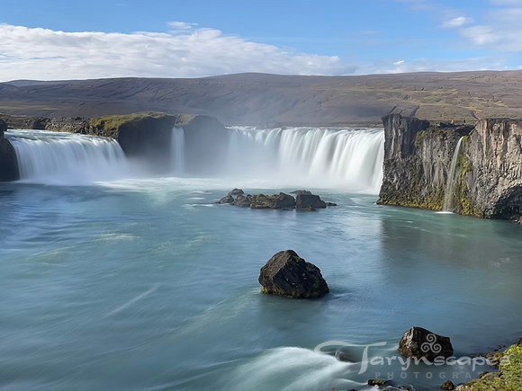 Silky waters flow from the Godfoss horseshoe into a still pool below