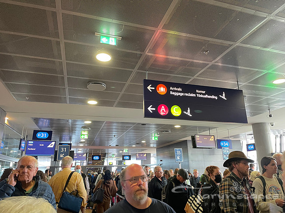 Gate full of people with signs above